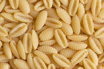 Pasta raw closeup background. Delicious dry uncooked ingredient for traditional Italian cuisine dish. Textured variety shapes. Top view. Copy space
