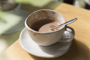 Hot cocoa in a white cup In a cafe on the table by the window in