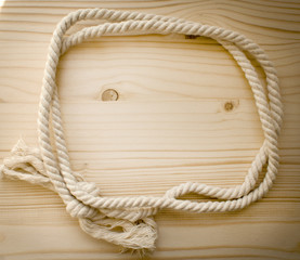 Round double rope frame on a wooden background. Sea border.