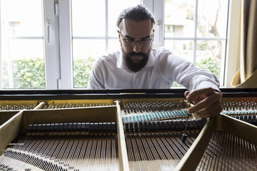 Piano tuner tuning grand piano