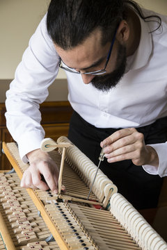 Piano tuner tuning grand piano