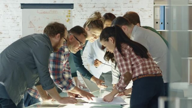Seven Stylish Standing Diverse People Lean on a Conference Table While Energeticaly Discussing Daily Business Plans.  Shot on RED EPIC (uhd). 