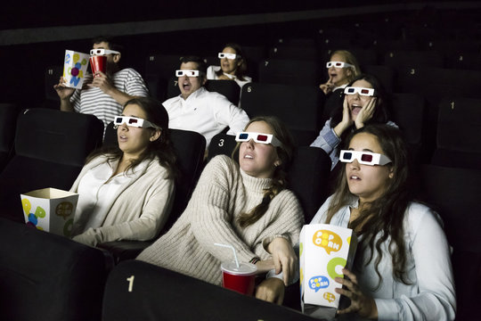 Scared people with d glasses watching a movie in a cinema