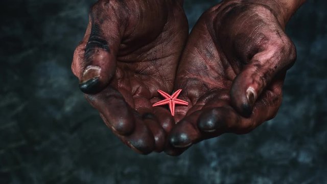 4k Technical Composition of Dirty Mechanic Hands Holding Starfish
