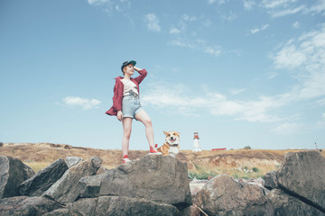 girl with welsh corgi dog on beach