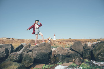 girl with welsh corgi dog on beach