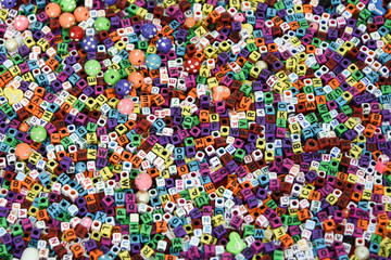 Alphabets in kinder garden school for kids, India.
Collection of colourful beads to make handmade jewellery/ bracelet names, in Rajasthan. heap of multi colored beads in an Indian street shop. 

