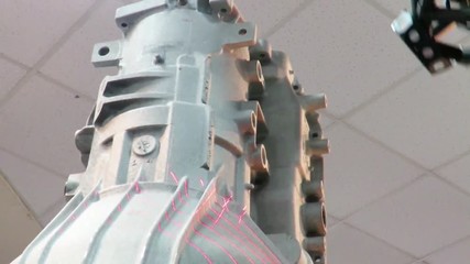 Automated robotic arm performing 3D laser scanning of a cast car engine block , in order to produce a computer model of the piece. - Powered by Adobe