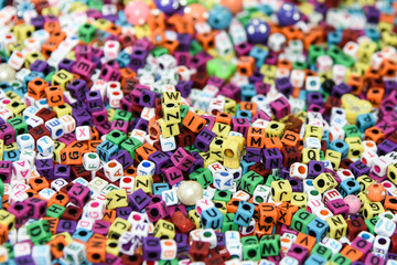 Collection of colourful beads/ blocks to make handmade jewellery/ bracelet names, in Rajasthan, India. heap of multi colored beads in an Indian street shop.
