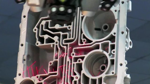 Automated robotic arm performing 3D laser scanning of a complex interior cast car engine block , in order to produce a computer model of the piece.