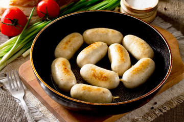 Homemade baked grilled meat chicken sausage in a cast iron pan o