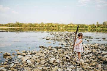 Fototapeta na wymiar girl holding a dry branch of the river