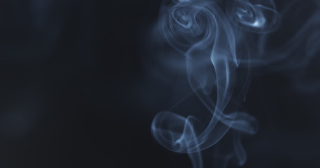 mystery blue smoke over dark background with copy space