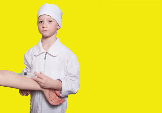 Boy dressed in doctor giving injection with syringe in hand on y
