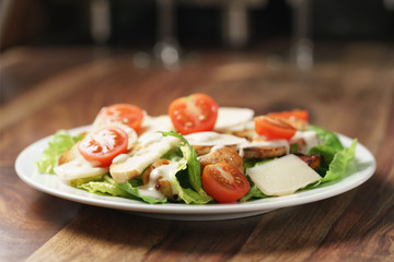 caesar salad with cherry tomatoes on wooden table