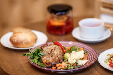 Grilled steak with vegetables and herbs on plate