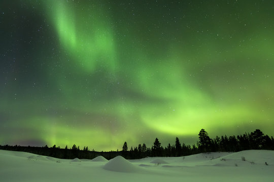 Aurora borealis over snowy winter landscape, Finnish Lapland