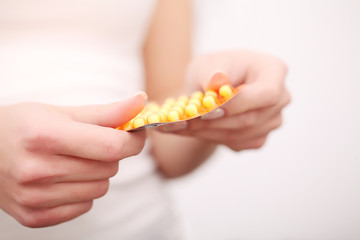 Closeup of woman's hands holding medicine pills