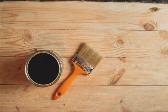 Redecoration Concept. Tin With Paint And Brush On The Wooden Floor. View From Above.