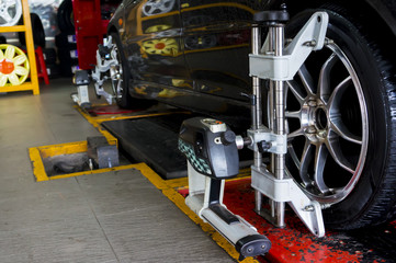 Car on stand with sensors on wheels for wheels alignment camber check in workshop