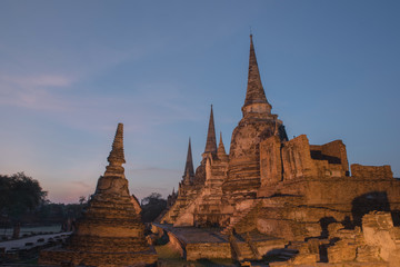 Ancient ruins of the temple Wat Phra Sri Sanphet national historic site with lights show at twilight time in Ayutthaya, Thailand.