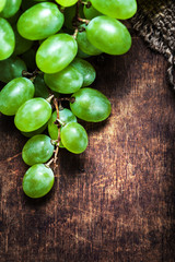 White Wine grape bunch over wooden background. Green grapes macr