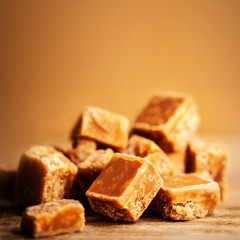 Salted caramel pieces and sea salt macro on wooden board with co
