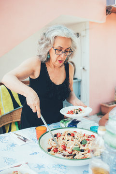 Woman serving pasta from serving dish