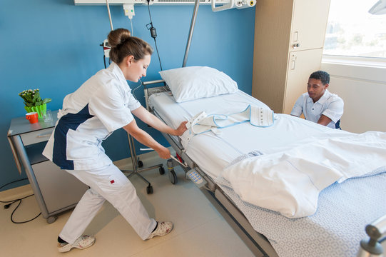 Hospital orderlies adjusting hospital bed