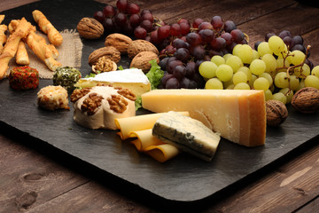 Cheese platter with different cheese and grapes 