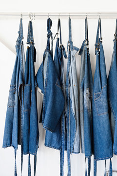 Denim aprons hanging in a row