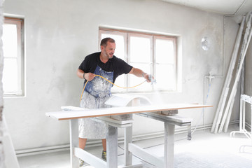 Man spray painting timber