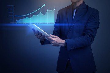 Close up of businessman holding financial graph with tablet comp