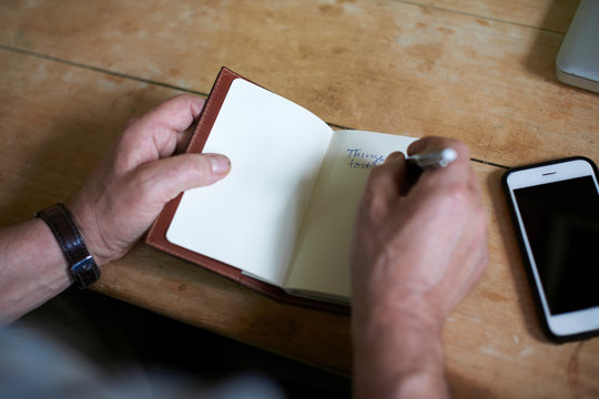 Man writing in notebook, close-up