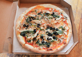 Original recipe idea of fresh traditional italian pizza pie - carbonara with bacon, egg, cheese and tomato sauce in delivery paper box on rustic wooden kitchen table background