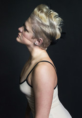 Naklejka premium photo portrait of blonde girl in a beige dress and veil on her face piercings in profile