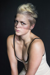 Naklejka premium photo portrait of blonde girl in a beige dress and veil on her face piercings