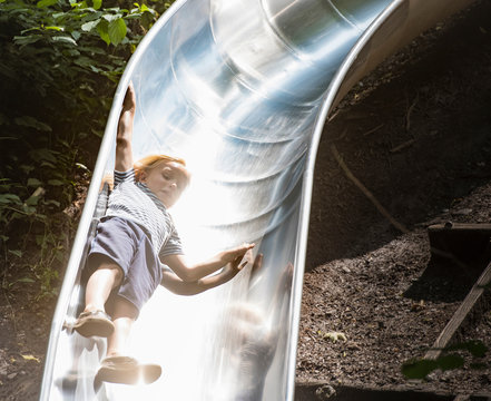 Boy sliding down playground slide