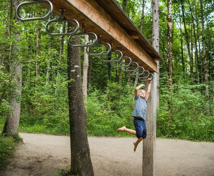 Boy hanging from monkey bars in playground