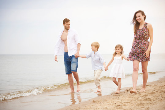 Family holding hands walking on beach