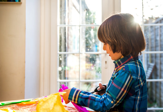 Boy cutting crepe paper to make pinata