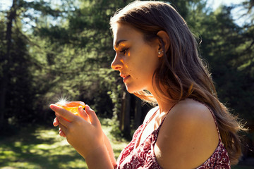 Young woman gazing at yellow crystal in forest, Sattelbergalm, Tyrol, Austria