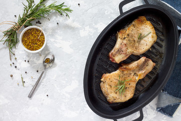 Meat grill. Pork on the bone in a cast-iron barbecue pan with ro