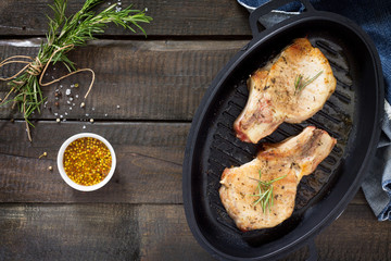 Meat grill. Pork on the bone in a cast-iron grill pan with rosem