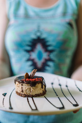 A young girl is holding a plate of dessert.