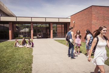 Teenage high school pupils chatting outside school