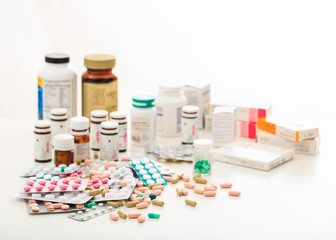 Stack of pills and containers on white background