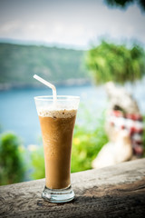 Glass Of Cold Coffee On Wood outside. Tropical island, Indonesia, Asia.