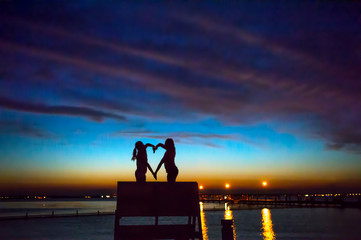 Children making heart shape with hands at sunset, Seaside Park, New Jersey, USA