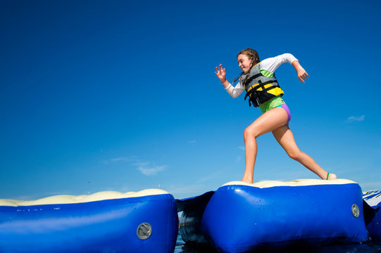 Girl running across inflatable platforms, Seaside Heights, New Jersey, USA